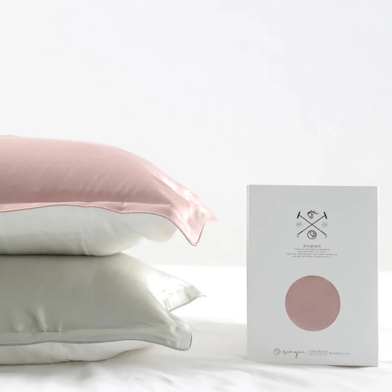 Pink and white silk pillowcases on a bed